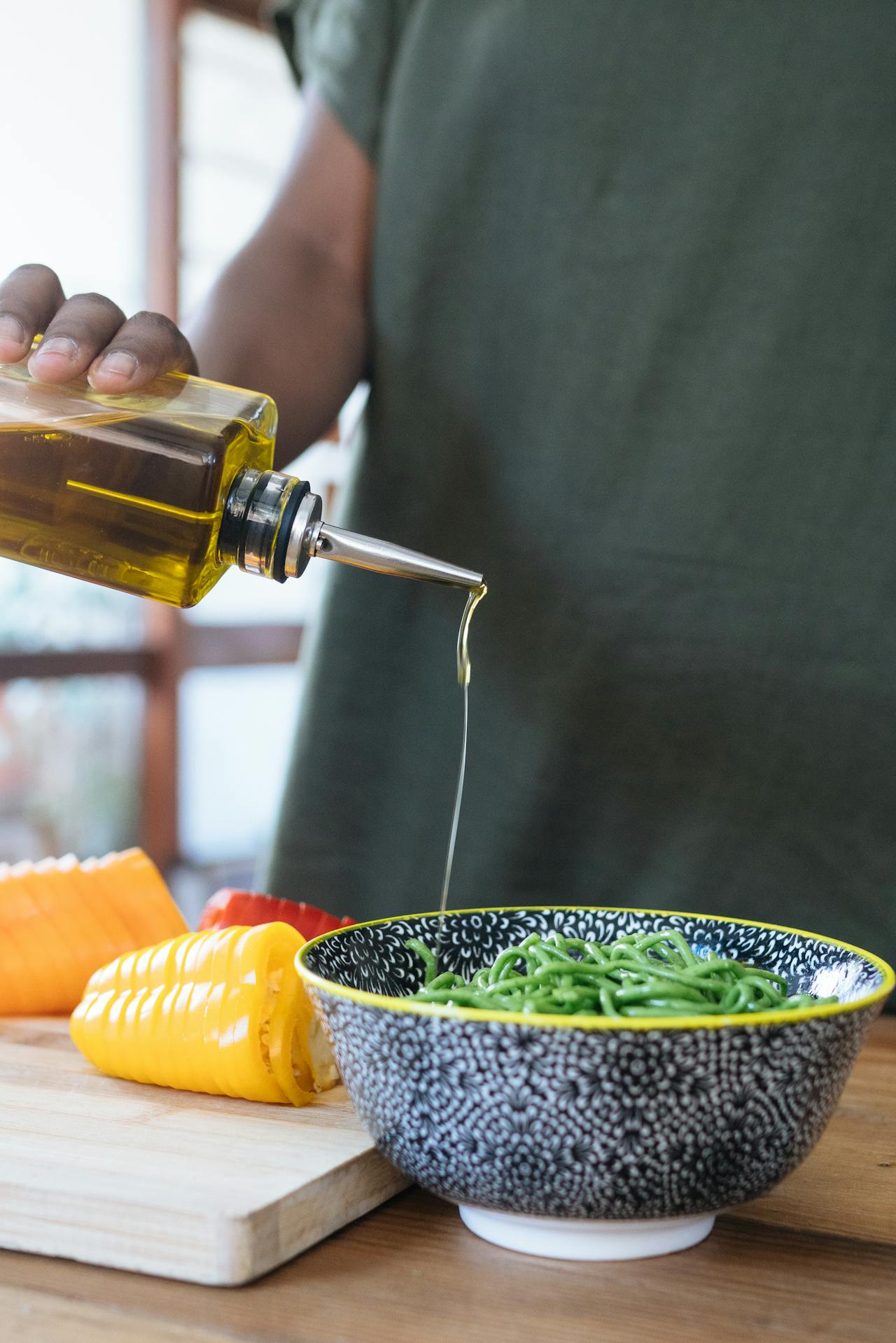pouring olive oil on greens